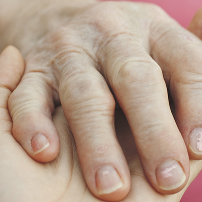 Up close image of two hands; one is resting comfortingly on the other