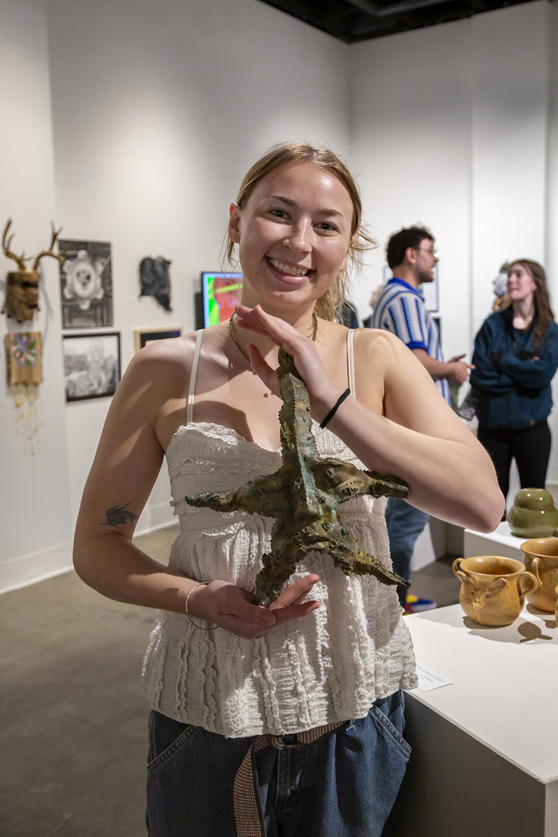 Second place award winner Keely Vatcher poses with her bronze casting, Caught in the Current. UAF photo by Sarah Manriquez