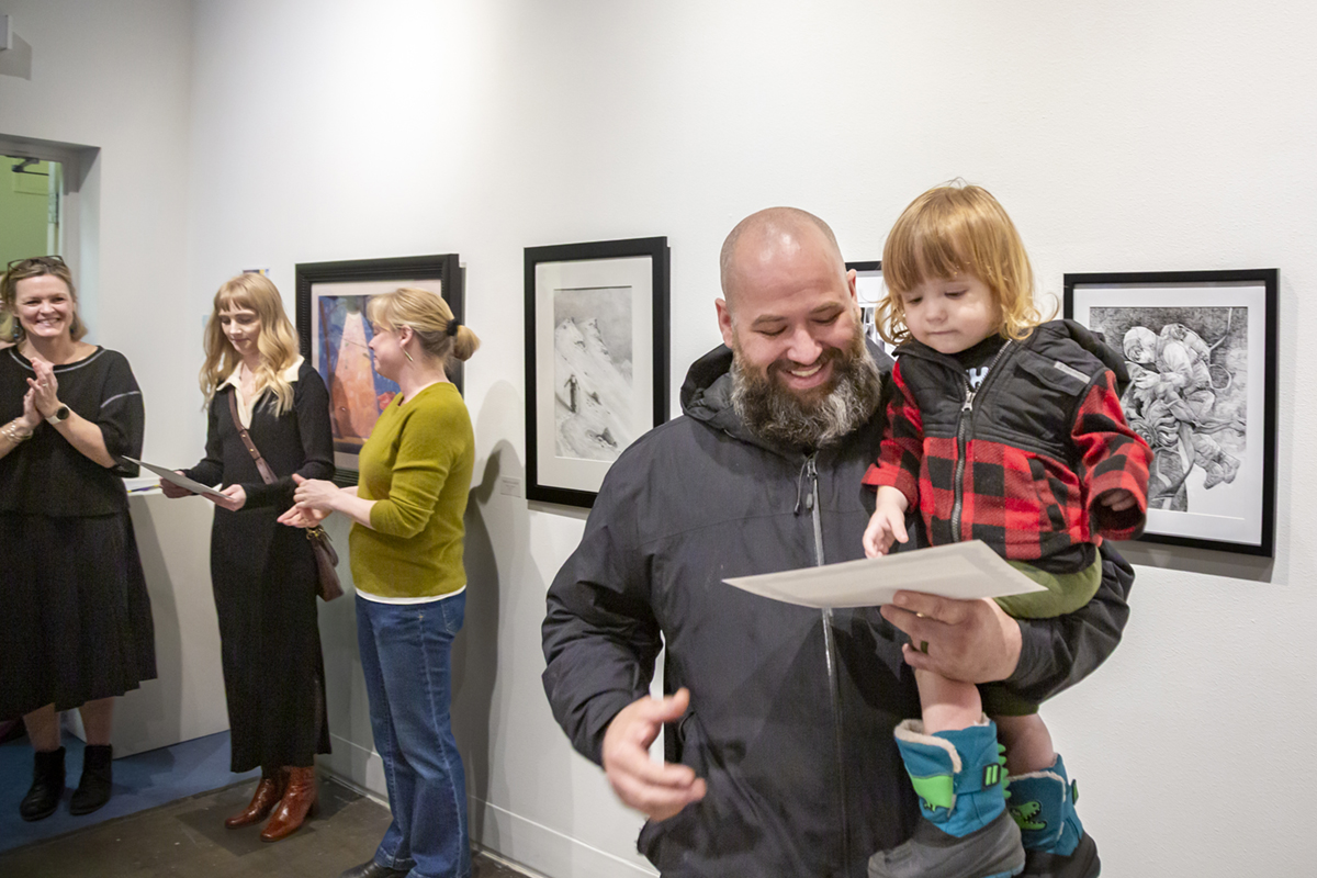 Kevin Carroll and his child admire his certificate. UAF Photo by Sarah Manriquez