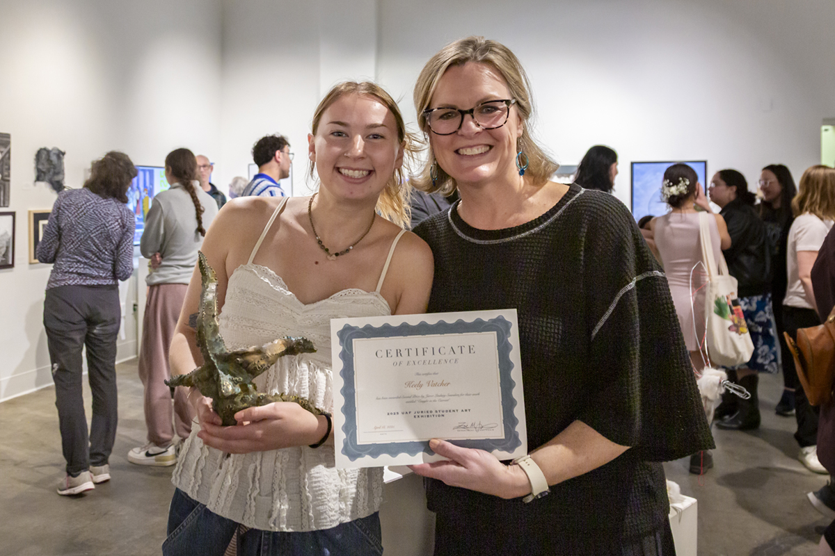 Keely Vatcher holds her 2nd place award-winning bronze sculpture, Caught in the Current. Associate Dean Carrie Baker holds Keely's certificate. UAF Photo by Sarah Manriquez