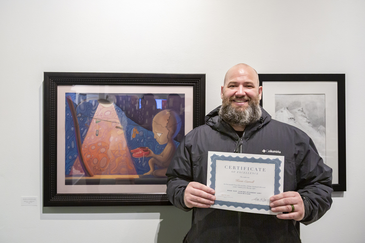 Kevin Carroll with his grand prize work, Children of the Burning Night. UAF Photo by Sarah Manriquez