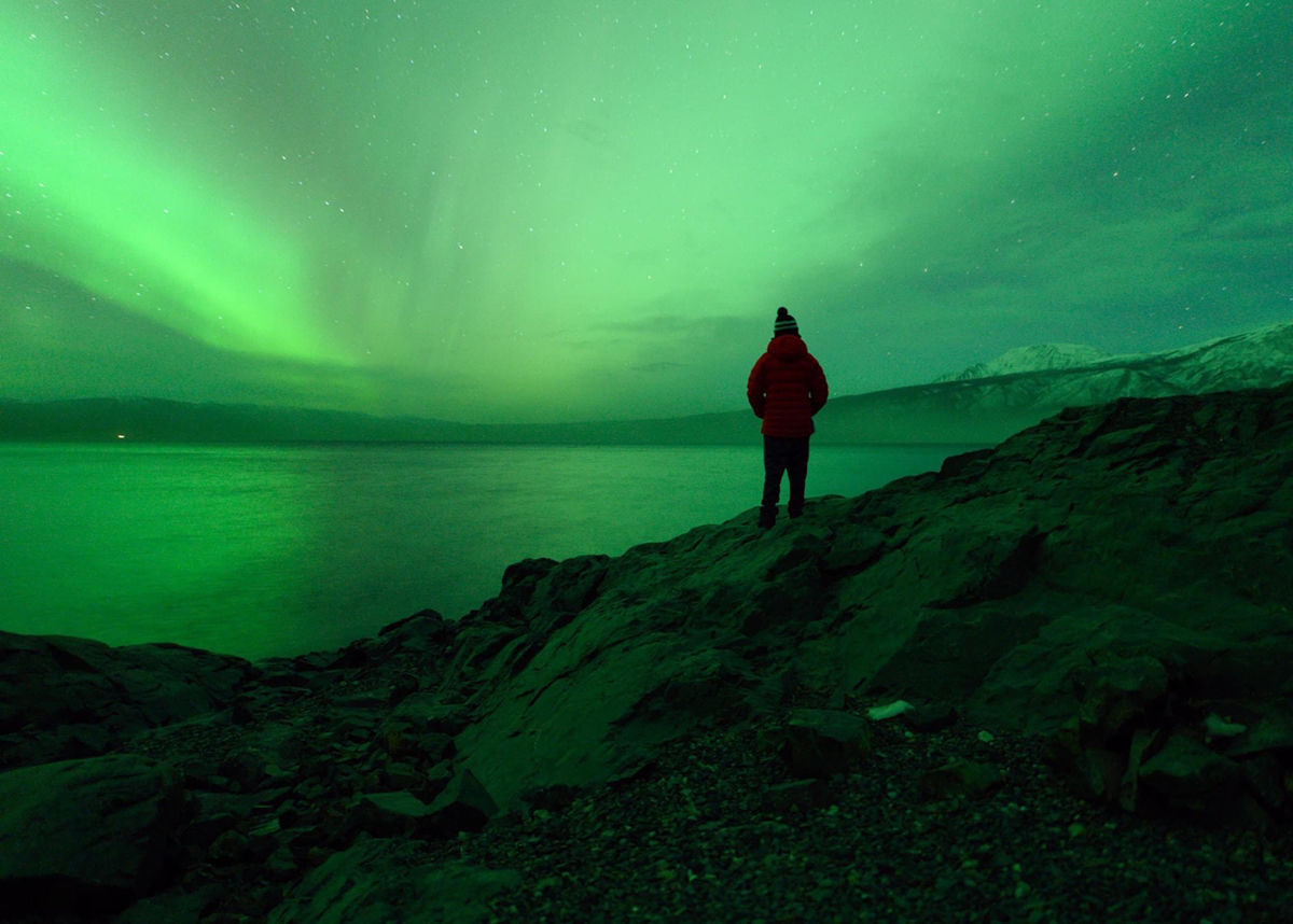 Andy Witteman watching the aurora over an icy lake. Photo courtesy of Witteman.