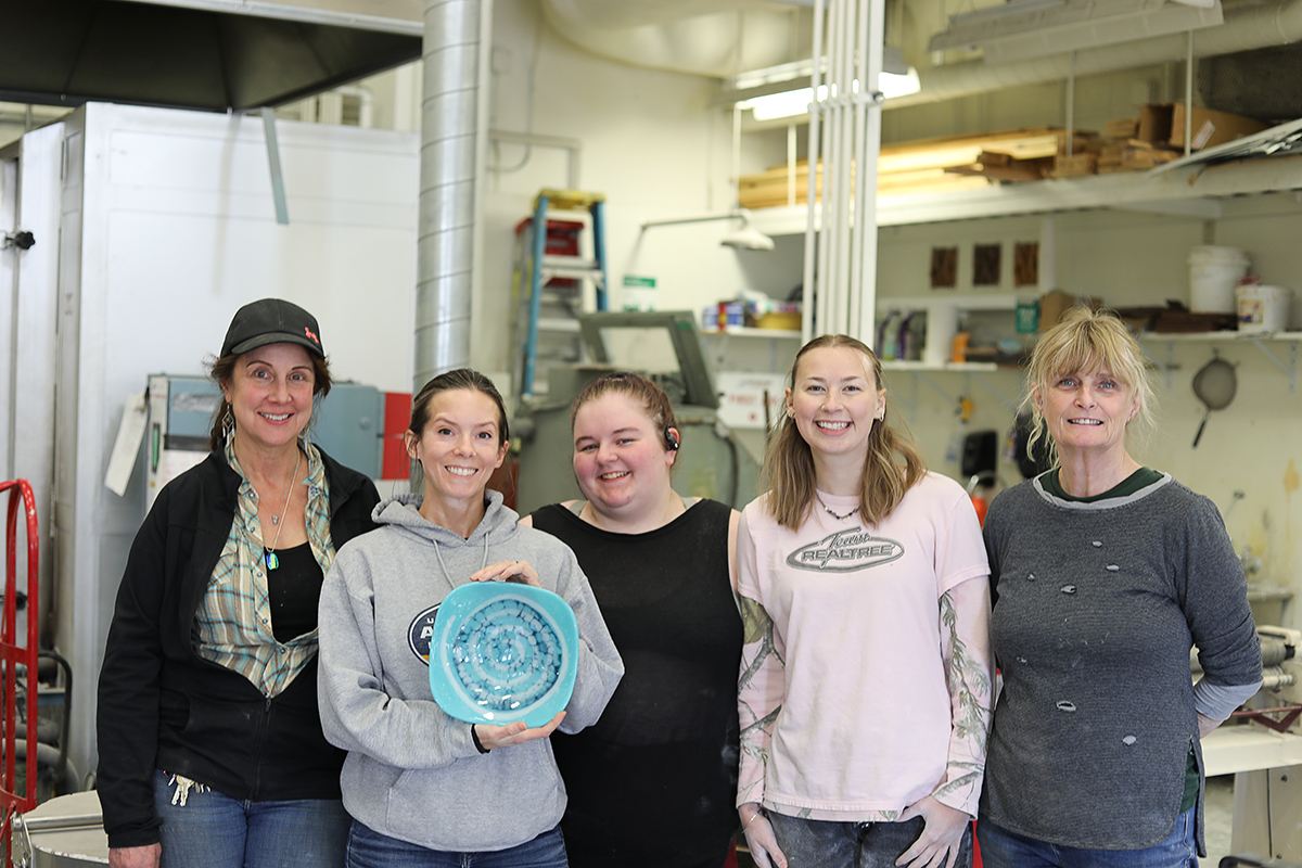 Professor of Sculpture Wendy Croskrey Sarah Dexter, Mia DenBoer, Keely Vatcher, and Terri Berrie in the UAF sculpture studio. Sarah Dexter is holding a fused glass piece. Photo courtesy of Dexter.