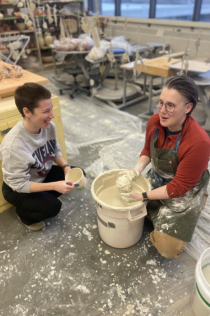 Jillian Muni (left) and Amy Edler (right) coat natural materials in porcelain slip during Dawn Holder’s hands-on workshop. Photo courtesy of Somer Hahm