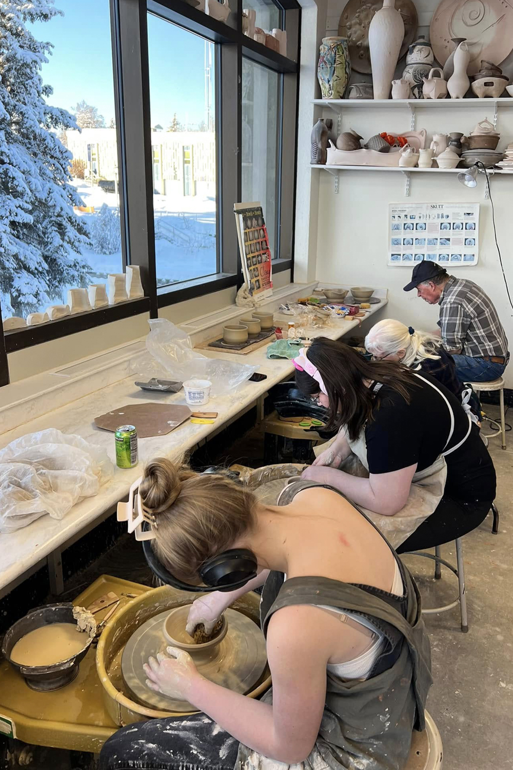 Ceramic artists throwing bowls on pottery wheels in UAF's Ceramics Studio for SCAGs 2025 Empty Bowls event. Photo courtesy of Olena Ellis