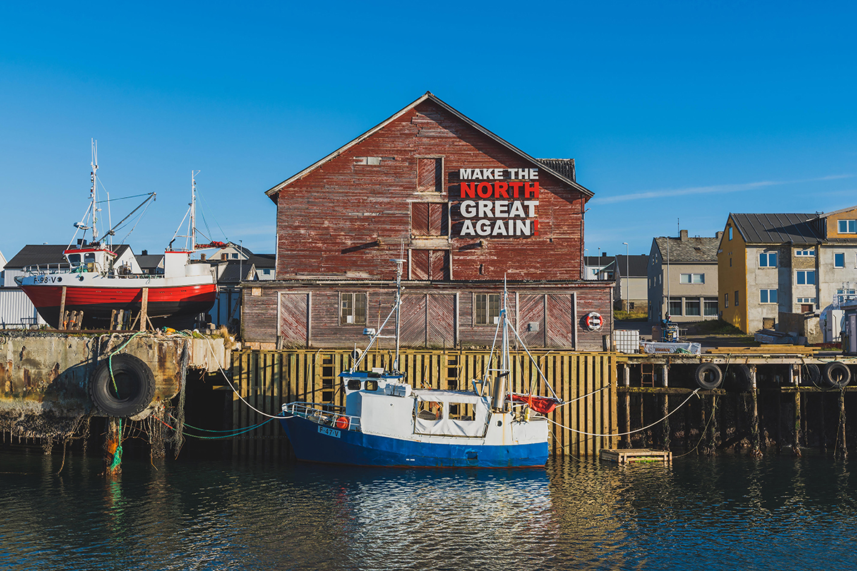 Make the North Great Again sign installed on the side of a wooden building on a pier in Vardø, Norway. Artists: Amund Sjølie Sveen and NORDTING