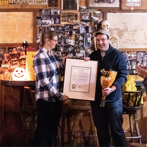 UAF Professor Brandon Boylan receives an Alaska Legislative Citation from Representative Ashley Carrick