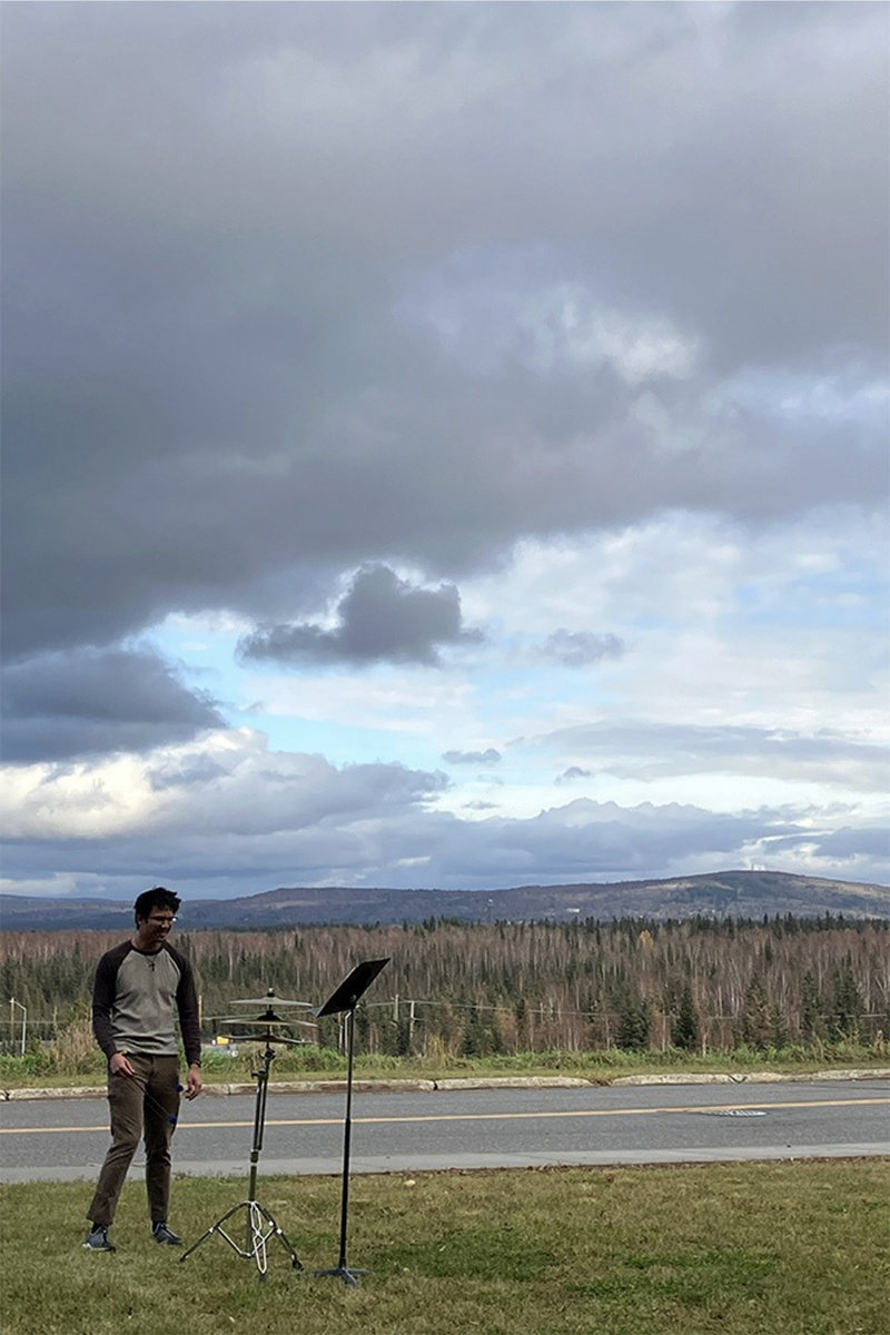Adrian Ducat next to a drum on the UAF campus in Fall 2025. Photo courtesy of Sean Dowgray