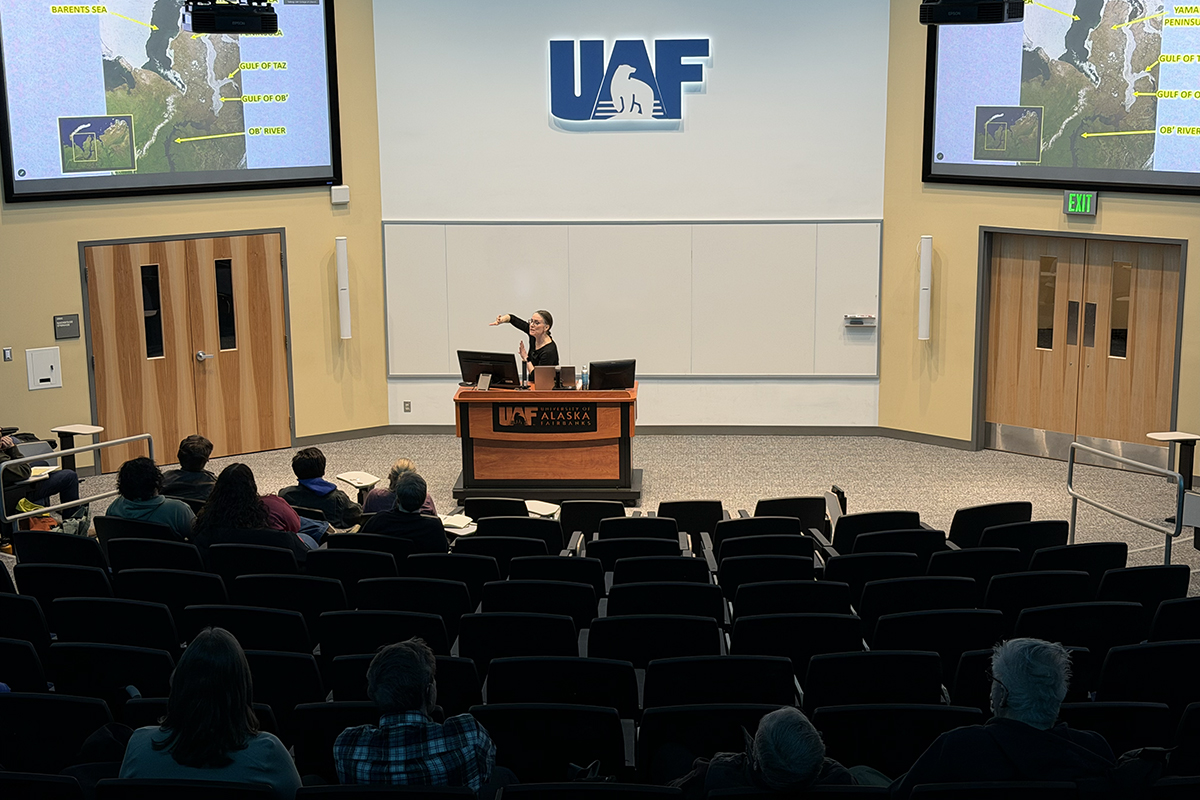 Dr. Erika Monahan gestures to her slide presentation at her talk in UAF's Schaible Auditorium.