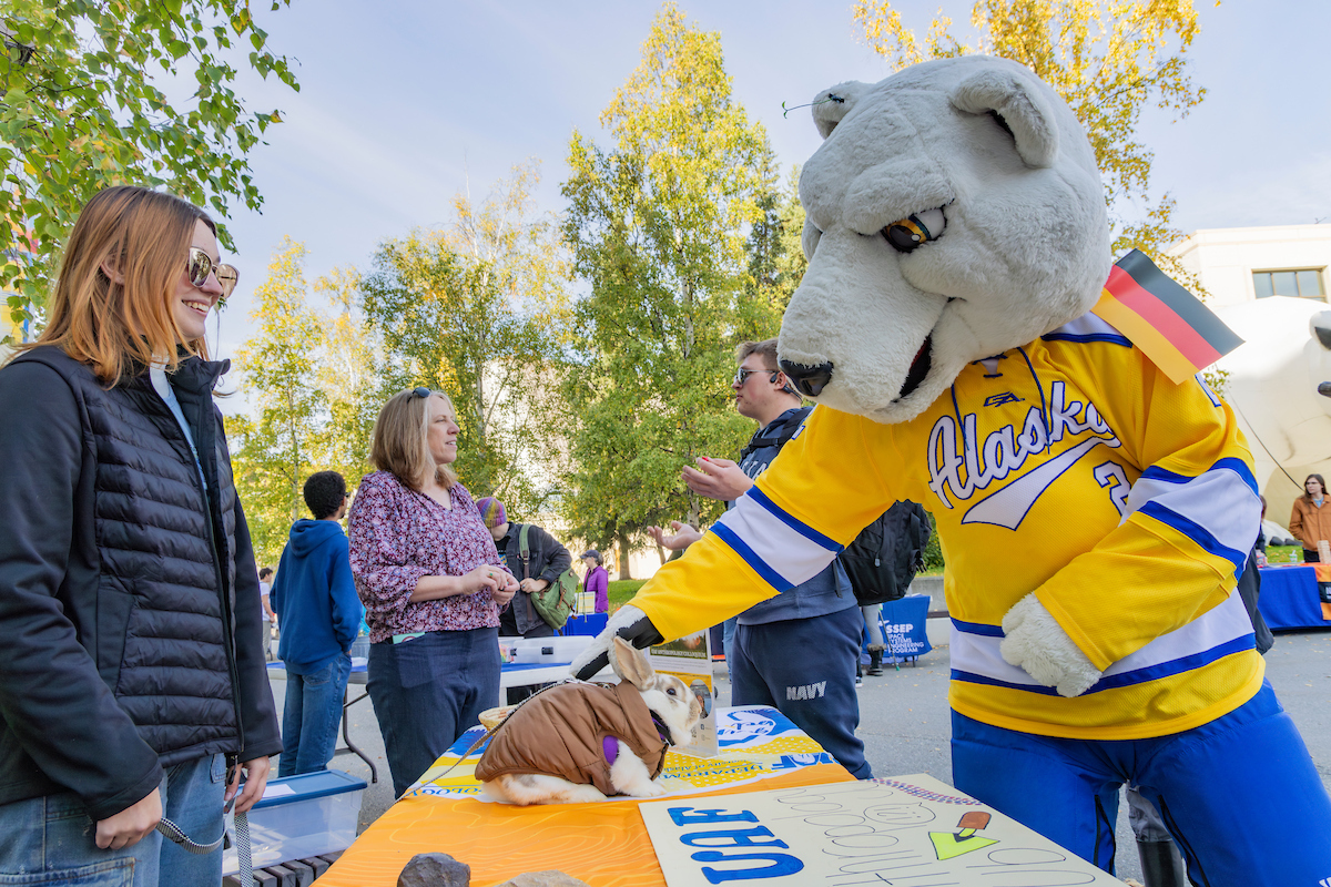 Nook makes friends with a rabbit while visiting the Department of Anthropology table during Party in the Park on Sep. 3, 2024. (UAF photo by Leif Van Cise)