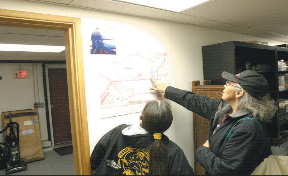 Kathy Mayo Roberts, far right, refers to a map of downtown Fairbanks posted on the clinic wall. With Roberts is Julie Roberts Hyslop.