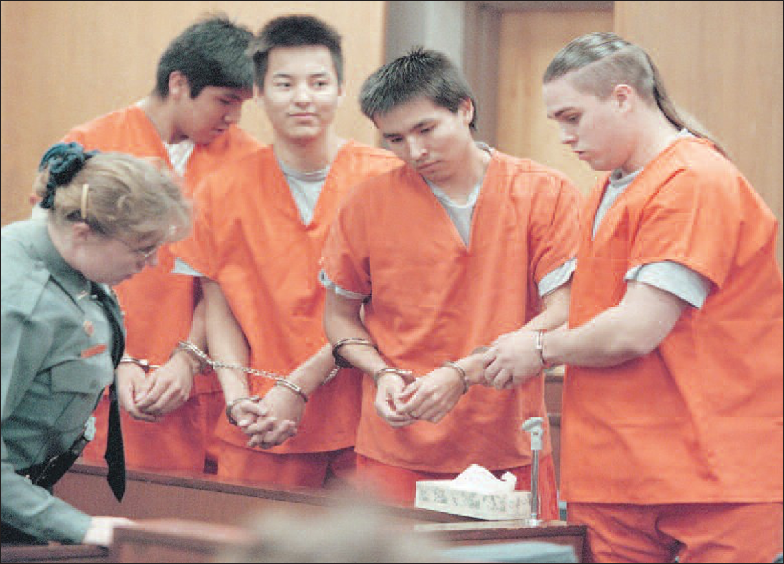 Court officer Cheryl Jasper, bottom left, escorts the four men accused of killing John Hartman into Fairbanks Superior Court for their arraignment in October 1997. From left are Eugene Vent, George Frese, Marvin Roberts and Kevin Peas
