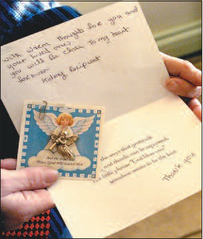 Evalyn Thomas displays a thank you card received from an anonymous organ transplant recipient who now carries a kidney that belonged to her deceased son, John. Hartman’s other kidney, liver and heart ventricles were all surgically transplanted to other patients.