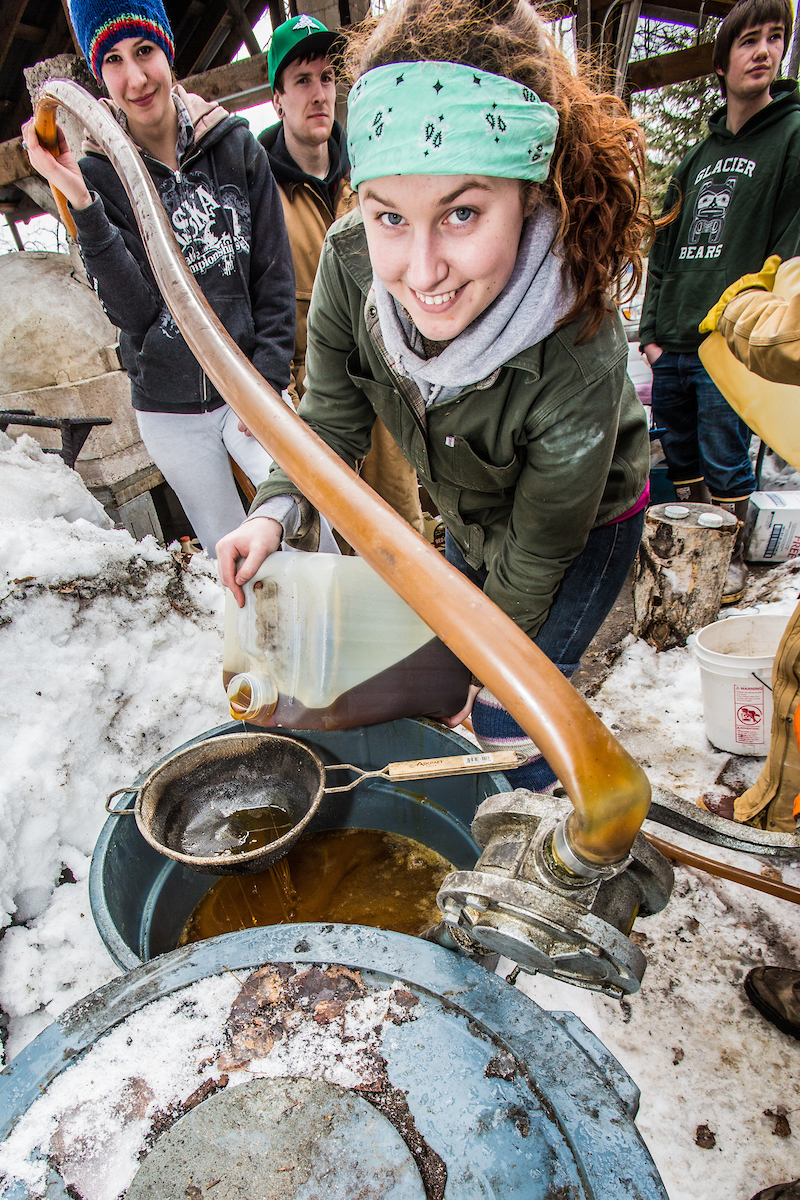 Ceramics student Katie Antal pours gallons of waste cooking oil through a screen before its pumped into a kiln to glaze ceramics projects made during the spring 2013 semester. | UAF Photo by Todd Paris