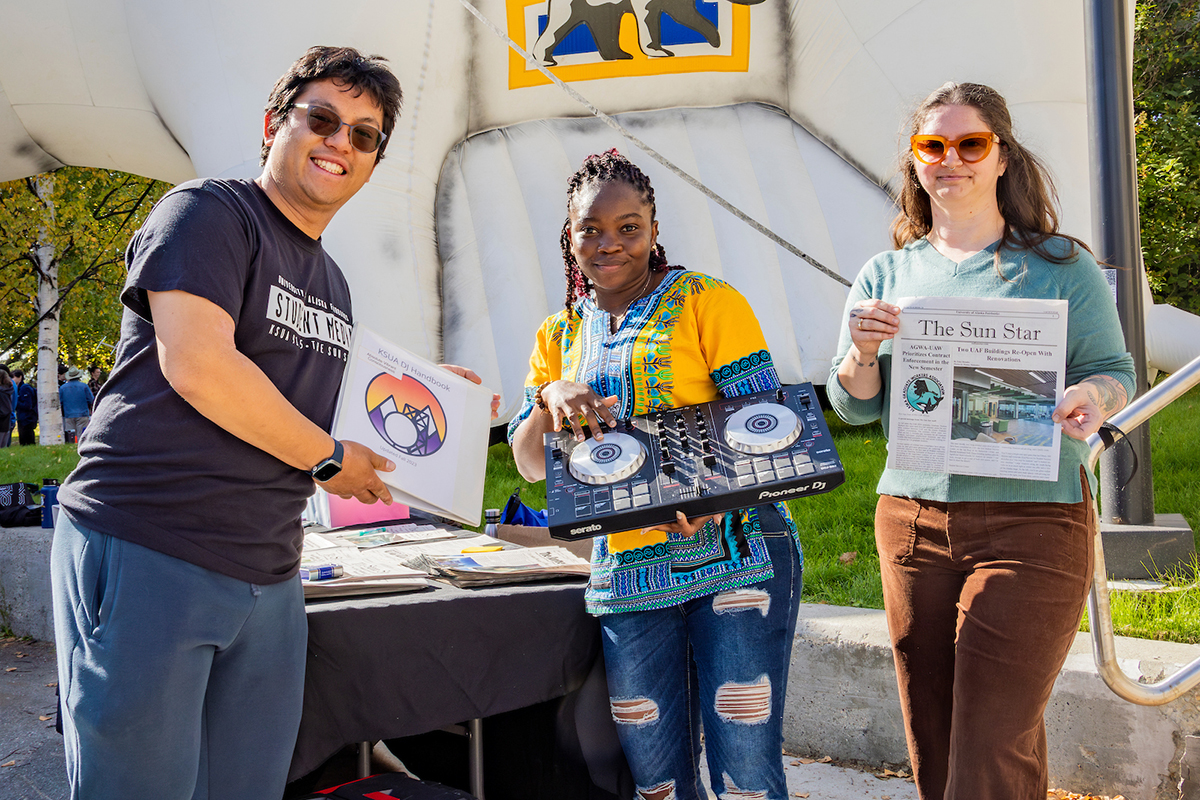 KSUA's Kjirsten Schindler trains new radio show host, Jake Knuth, on the various components of their studio  located on the second floor of the Wood Center, 7/29/24. (UAF photo by Leif Van Cise)