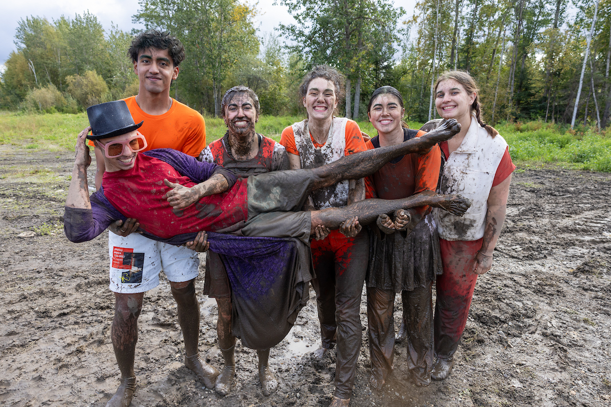 Team Chocolate Factory pose as teams compete in the New Student Orientation Mud Volleyball Tournament in the Nenana Parking Lot on the UAF campus Saturday afternoon, August 24, 2024. UAF Photo by Eric Engman