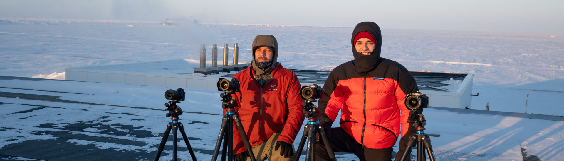 Two people with four cameras on tripods in Utqiagvik