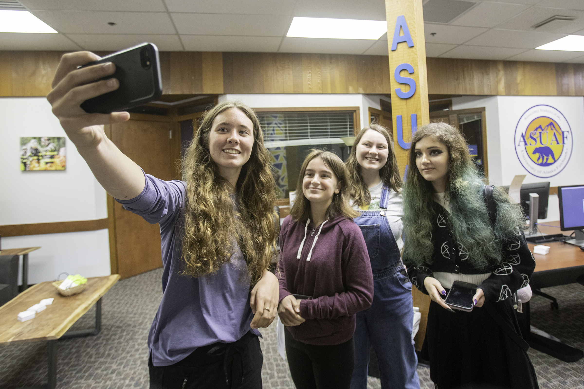 The UAF campus was abuzz with activity on the first day of fall classes as students (from left) Sarah Parks, Abbey Ames, Savannah Cowley and Jasmyne Rutan take a selfie photograph in the ASUAF student government office in the Wood Center for their Communication & Journalism 131 class scavenger hunt Monday, August 29, 2022. | UAF Photo by Eric Engman