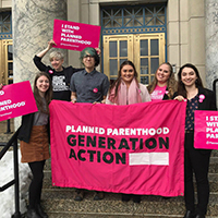 Generation Action club members holding bright pink banners