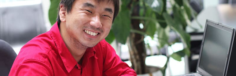 Student with laptop smiling at camera