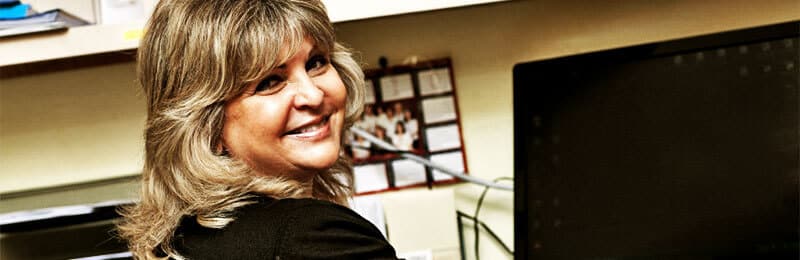 Woman looking back over her shoulder smiling at the camera