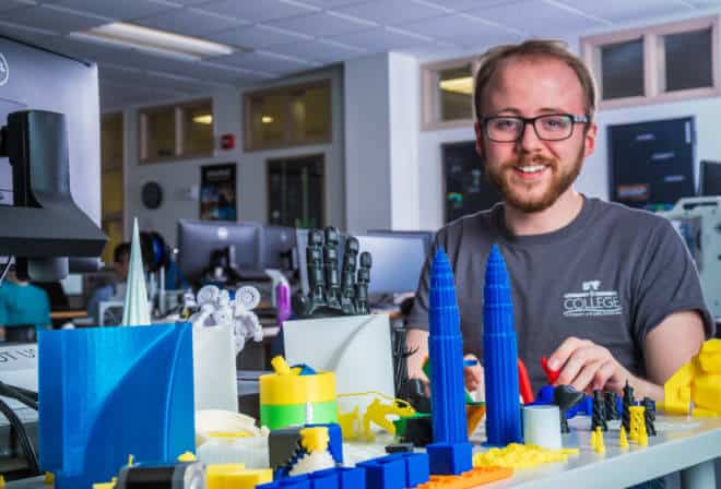 Program assistant Joel Sturm, who maintains the UAF Community and Technical College 3-D print lab, poses with items fabricated by the printers.