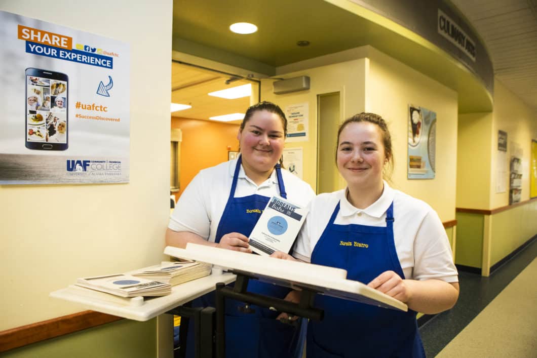 Two female culinary students smile at the camera
