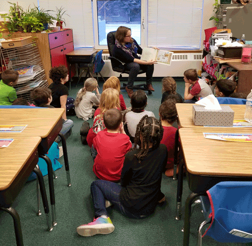 CLara reading the book to children