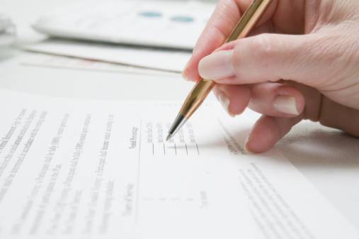 Image of a pen writing on a form paper