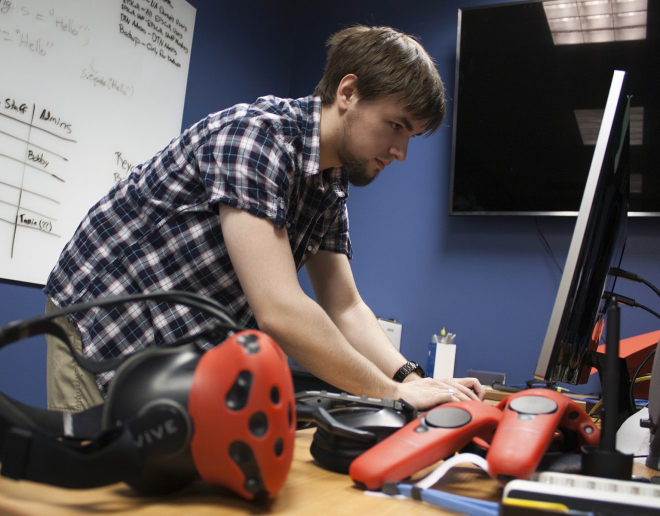 Photo by Tom Moran/Alaska NSF EPSCoRRecent University of Alaska Fairbanks graduate Tristan Craddick sets up a virtual reality experiment on the UAF's West Ridge. A VR headset and controllers sit in the foreground.
