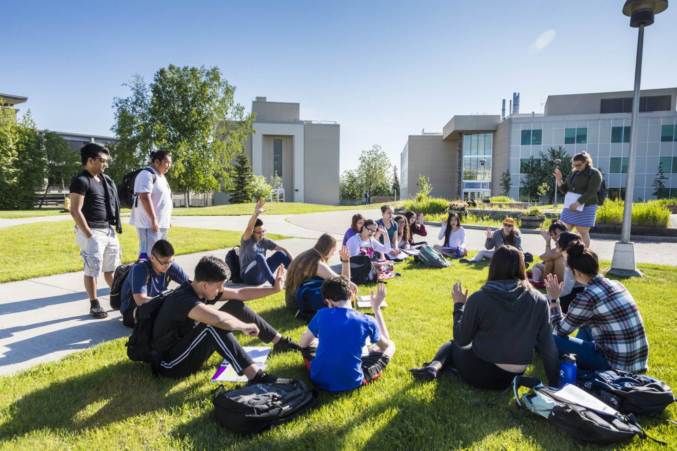 Rural Alaska Honors Institute students taking Introduction to College Writing conduct class outside at Cornerstone Plaza Friday June 8, 2018.