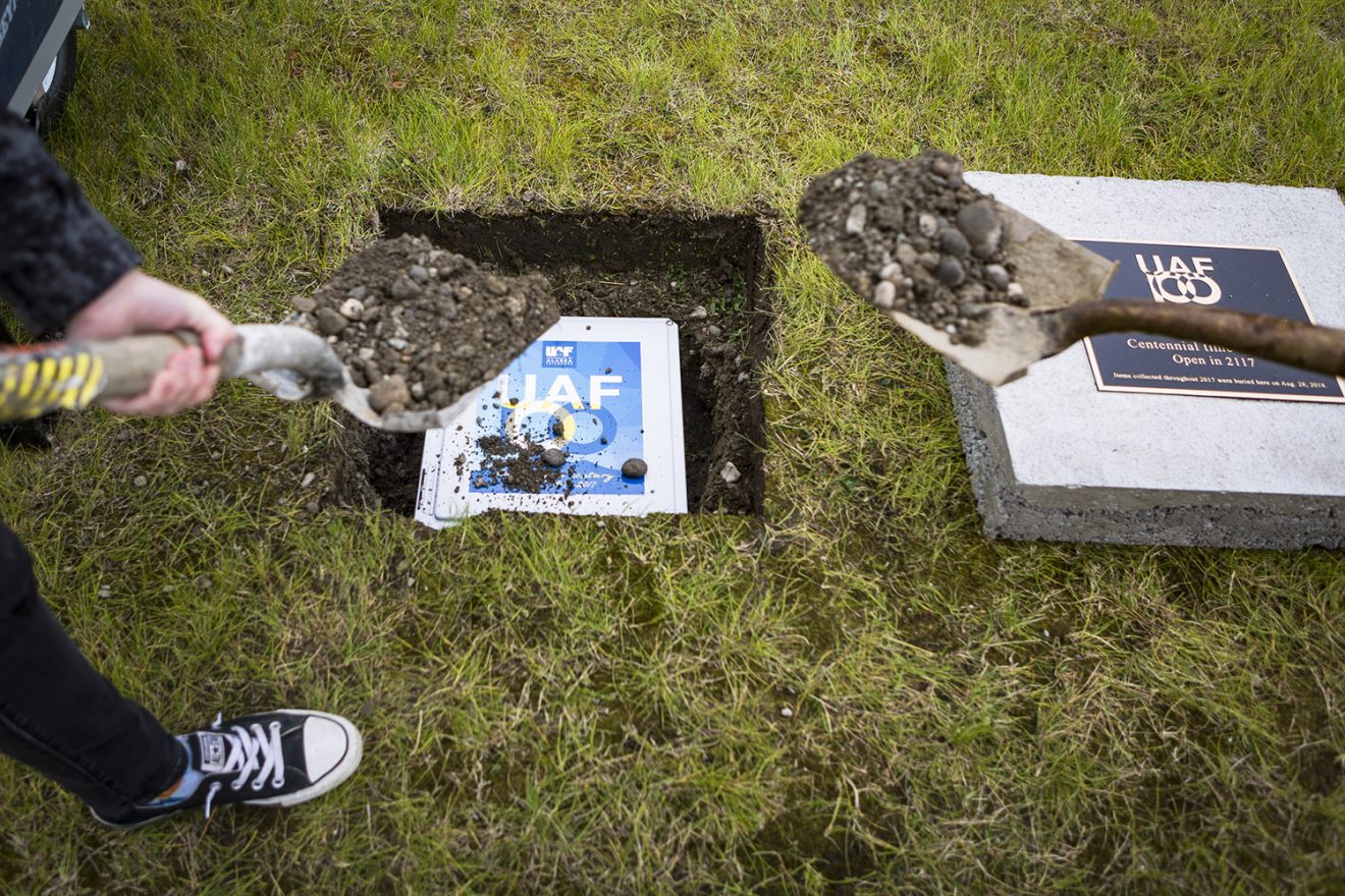 Director of Wood Center Cody Rogers and Assistant Director of Student Leadership and Involvement Heidi Shepard bury the UAF Centennial time capsule is buried underground next to the Cornerstone Tuesday, August 28, 2018 at the Fairbanks campus. The capsule is slated to be opened in 2117.