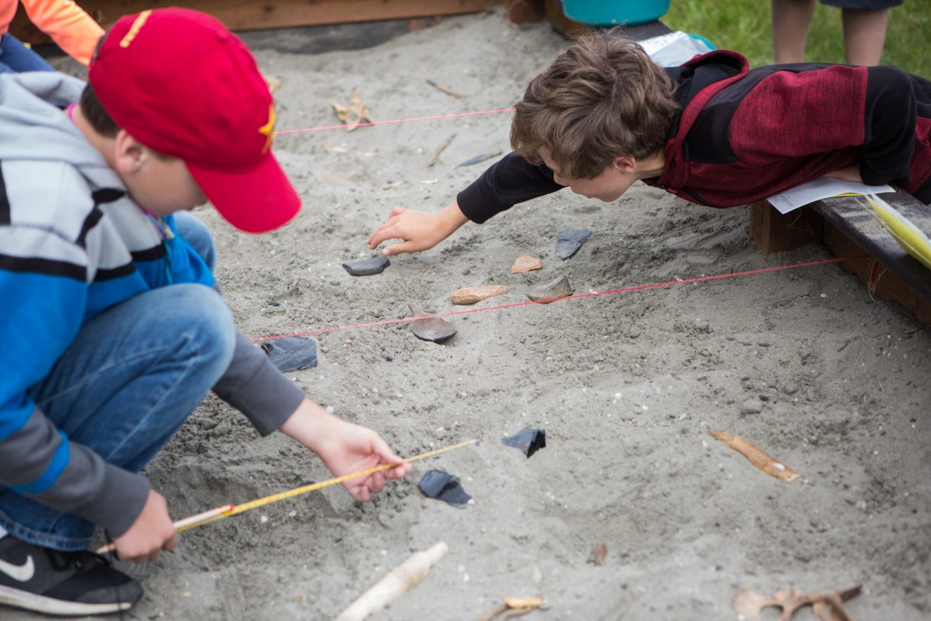 Students examine artifacts at the UAF summer archaeology camp Tuesday, July 10. UAF photo by Jessie Doble.