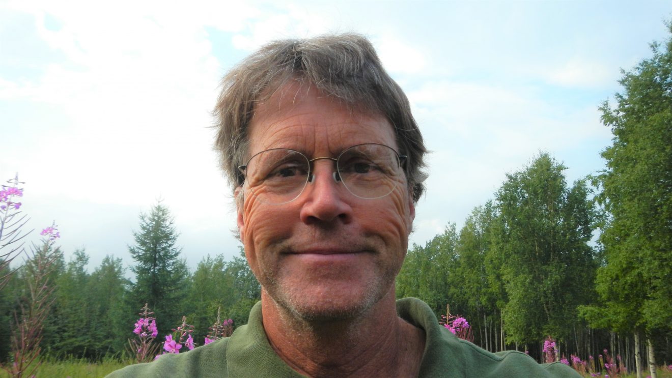 Dan Mann. Fireweed and birch trees are behind him.