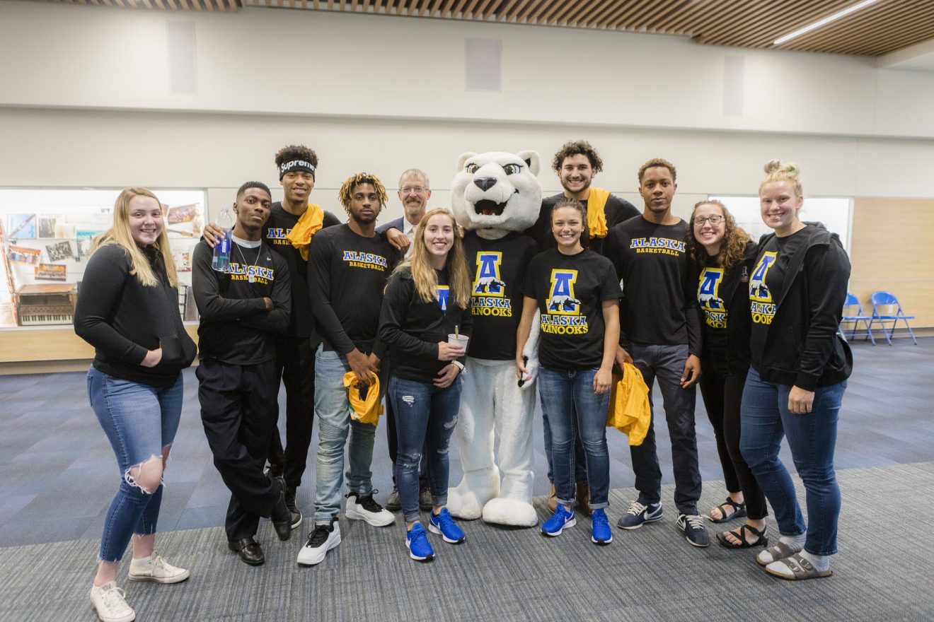 Chancellor Dan White poses with members of the Alaska Nanooks teams in the Regents' Great Hall following Convocation 2018.
