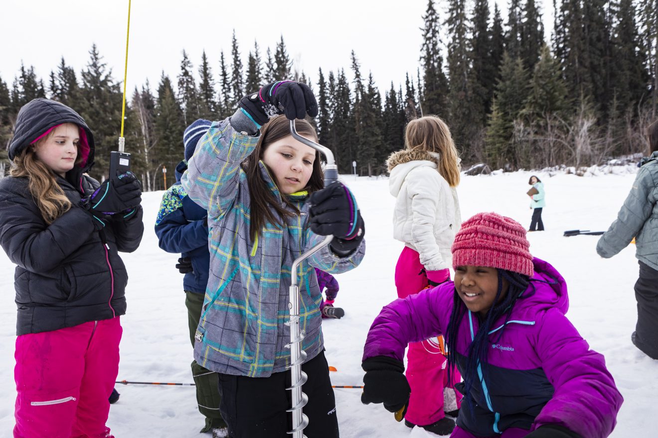 Fourth-graders measure ice and explore the surrounding ecosystem on Noyes Slough as part of the new “Fresh Eyes on Ice” program led by Chris Arp and Katie Spellman on Wednesday, March 20, 2019, in Fairbanks.