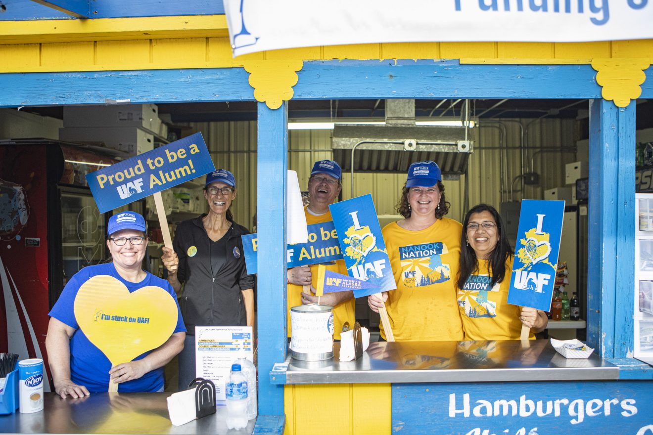 Anupma Prakash, right, poses with others in the Alumni Association hamburger booth.
