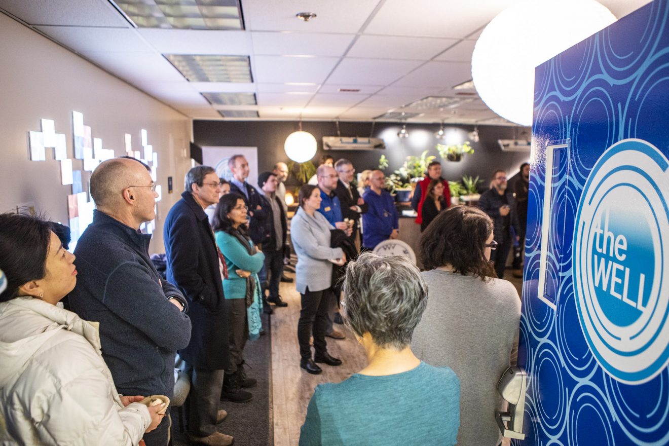 A crowd in a room with subdued lighting.