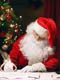 Santa writing letters with a Christmas tree behind him.