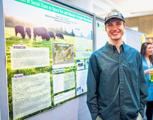Student in front of project poster.