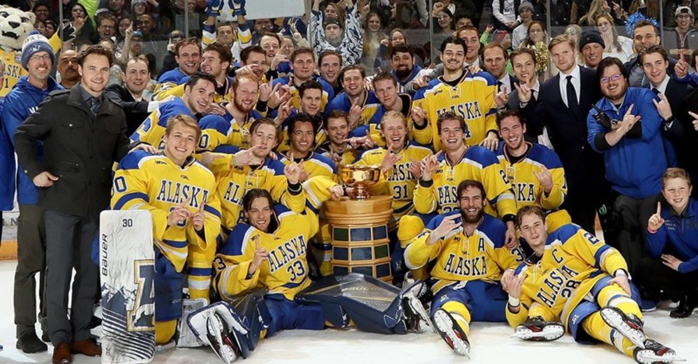 Hockey team and coaching staff on the ice with the Governor's Cup trophy.