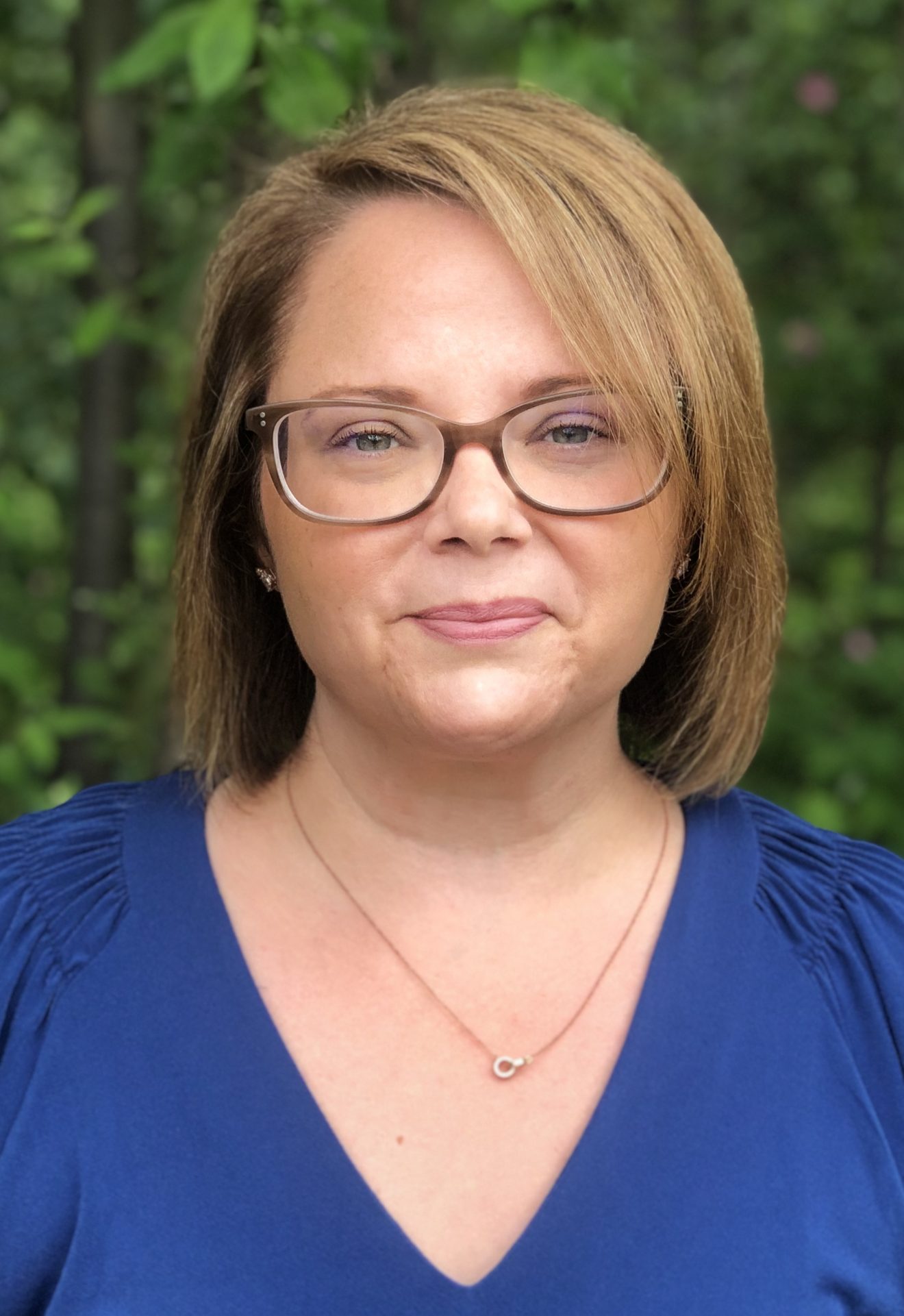 Head shot of Holly McDonald in front of a tree or bush