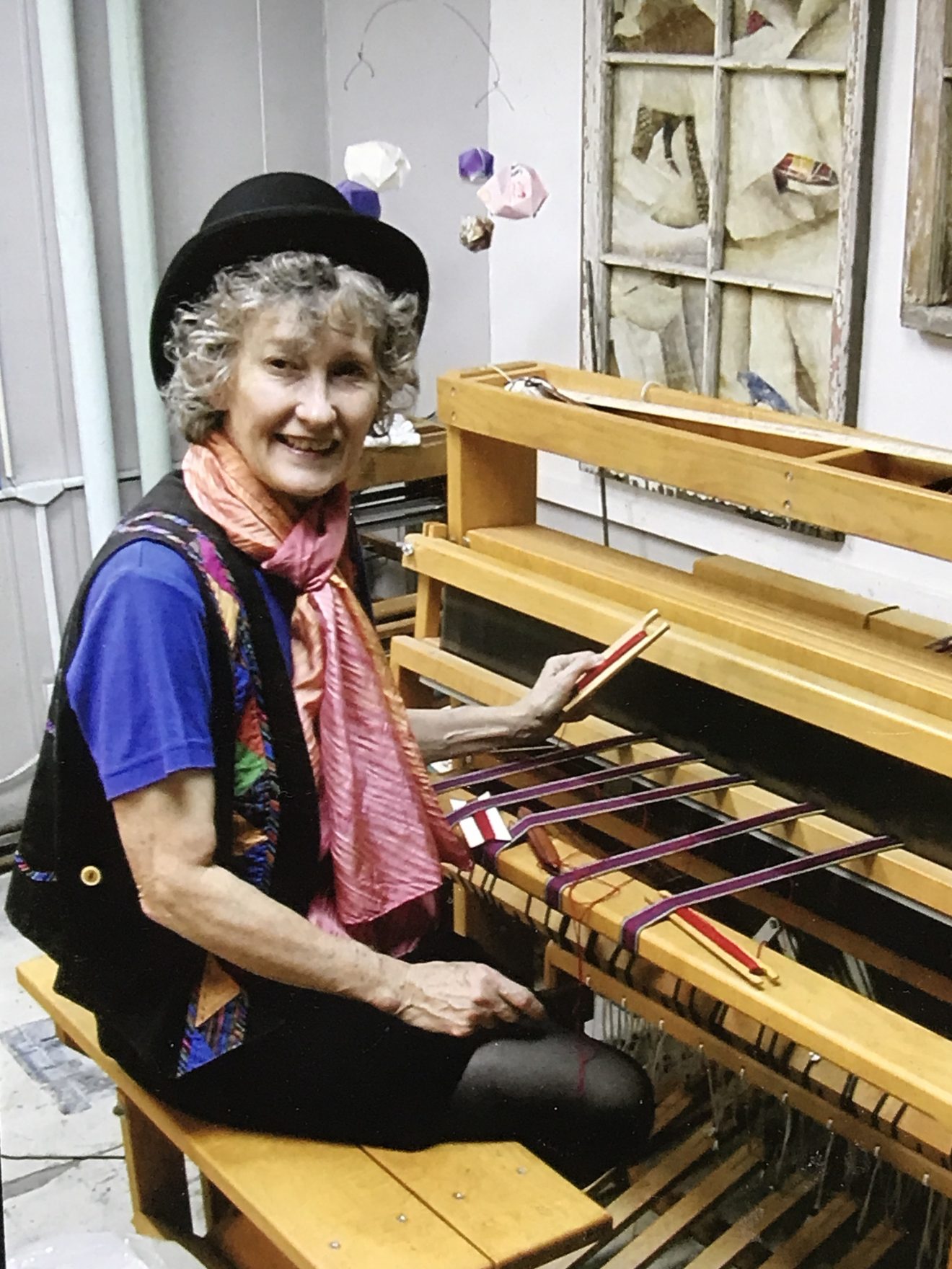 Picture of a woman sitting at a loom.