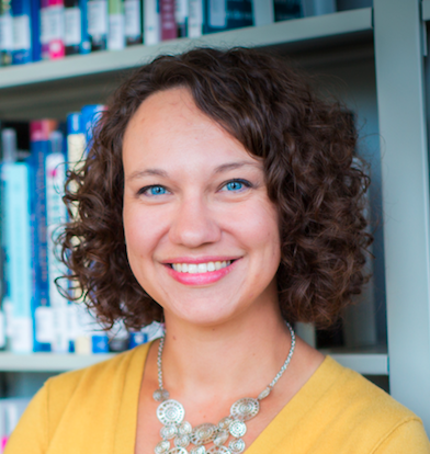 Head shot of Kristin Timm in front of bookshelves.