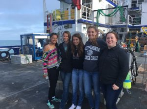 A group of five students stand on board a ship.
