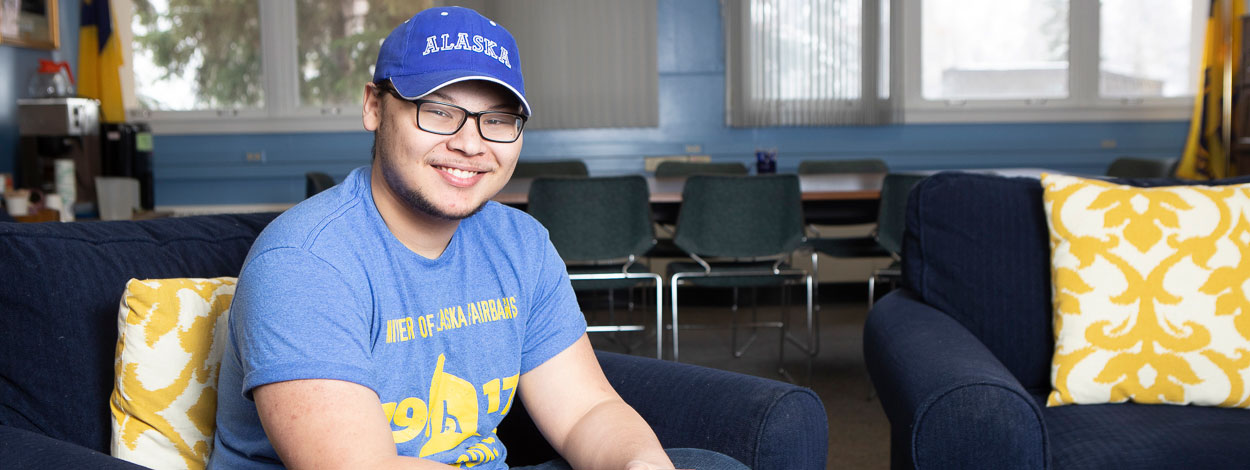 Student sitting in the lounge of the alumni association.