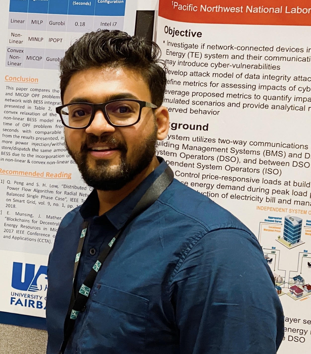 A man stands in front of two research posters hanging on a display board.