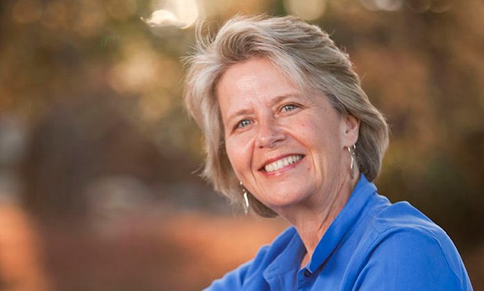 Head shot of a woman who appears to be sitting outside.