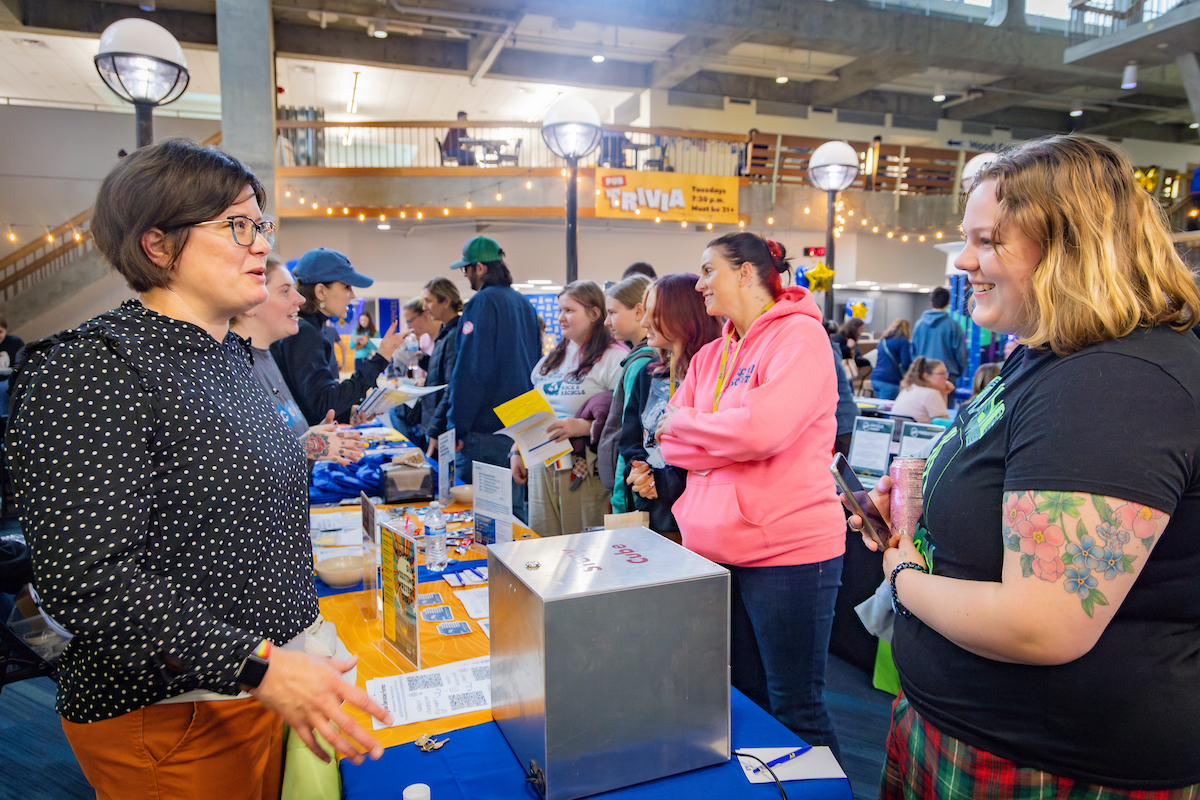First year student, Shelby Brandon (right) learns about the Story Cube from English Department Chair, Sarah Stanely, during the Student Success Resource Fair in the Wood Center as part of New Student Orientation week, Aug. 22, 2024. (UAF photo by Leif Van Cise)