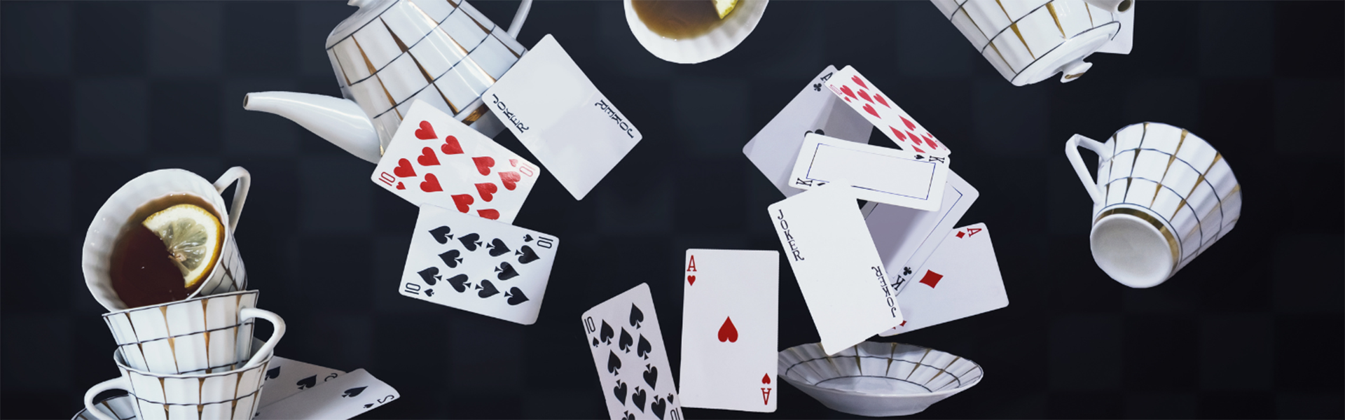 Cards and teacups on a black checkered background